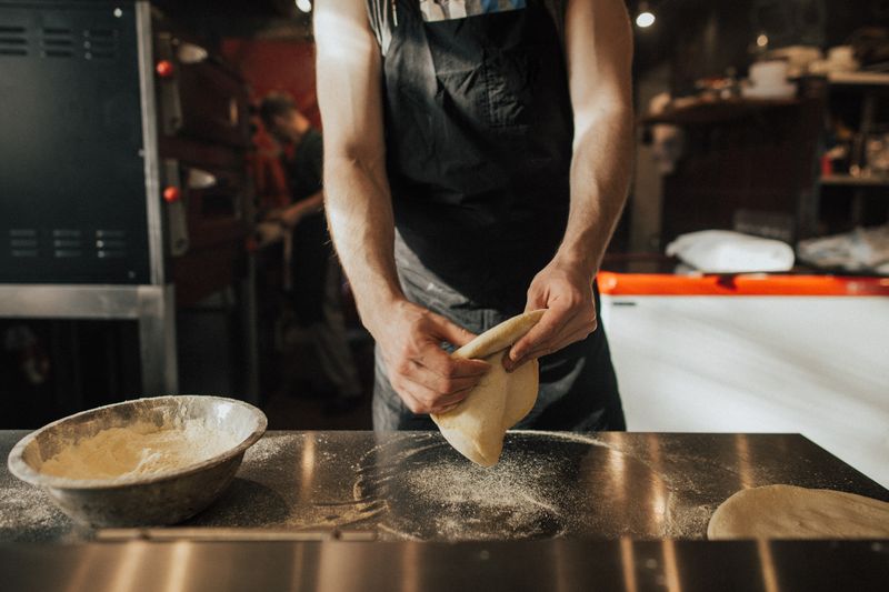Dions head chef at the chef's table preparing dion's pizza
